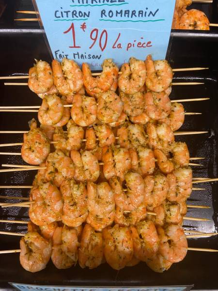 Préparation de brochettes de crevettes marinées au citron et romarin dans une poissonnerie à Fécamp